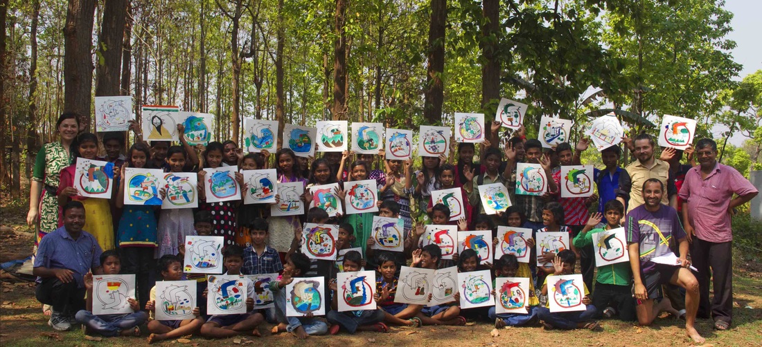 Dozens of children holding up their painted hearts at Jongal Mahal School, Jhilimili - Hearts of the World tribal workshop with the JAGO Foundation