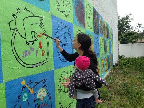 Hearts of the World community mural painted with Beautify Earth on Rockaway Beach Boulevard, New York